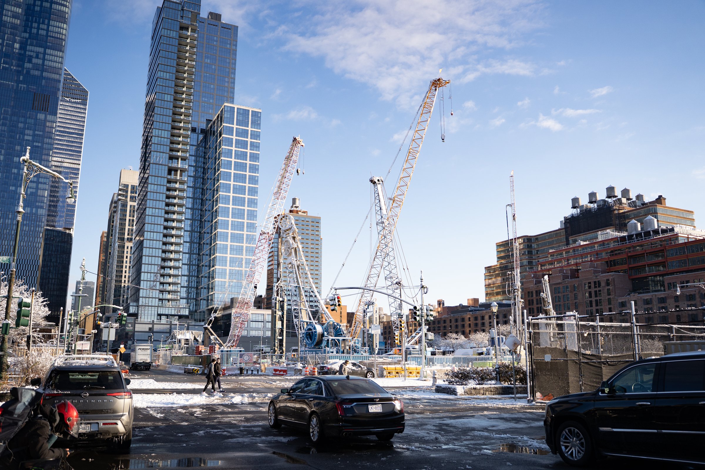 NYC construction site with cranes and modern skyscrapers in winter
